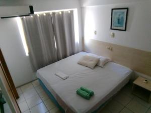 a small bedroom with a white bed and a window at Silva Hospedagem AMERICAN FLAT BEIRA MAR apartamento por temporada in São Luís