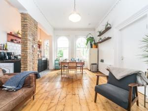 uma sala de estar com um sofá e uma mesa em Pass the Keys Rustic and Quirky Flat in Charming Charlton Village em Londres