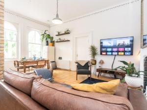 a living room with a couch and a tv at Pass the Keys Rustic and Quirky Flat in Charming Charlton Village in London
