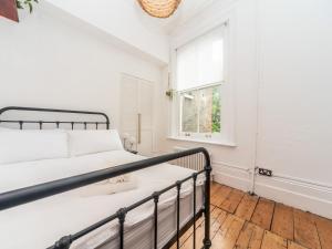 um quarto com uma cama e uma janela em Pass the Keys Rustic and Quirky Flat in Charming Charlton Village em Londres