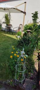un jardín con flores en un patio con sombrilla en Tinyloft, en Beerfelden