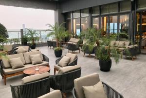 a hotel lobby with couches and tables and plants at Grand K Hotel Suites Hanoi in Hanoi