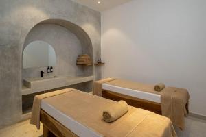a bathroom with two beds and a sink and a mirror at Aldiana Club Zanzibar Kwanza in Kizimkazi