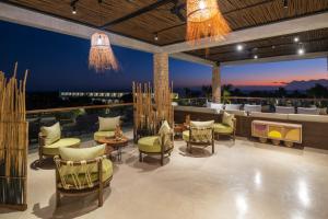 a patio with chairs and tables and a view at Aldiana Club Zanzibar Kwanza in Kizimkazi