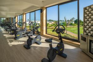 a row of exercise bikes in a gym with windows at Aldiana Club Zanzibar Kwanza in Kizimkazi