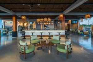 a lobby with a bar with green chairs at Aldiana Club Zanzibar Kwanza in Kizimkazi