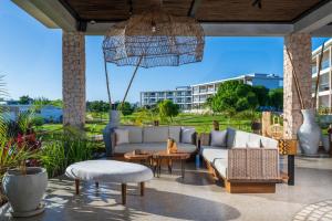 a patio with a couch and chairs and an umbrella at Aldiana Club Zanzibar Kwanza in Kizimkazi