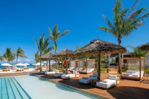 a pool at a resort with lounge chairs and umbrellas at Aldiana Club Zanzibar Kwanza in Kizimkazi