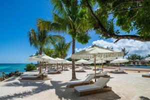 a beach with chairs and umbrellas and the ocean at Aldiana Club Zanzibar Kwanza in Kizimkazi