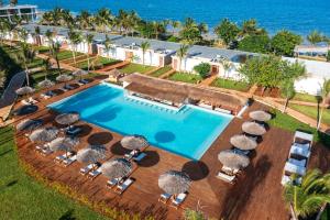 an aerial view of a resort pool with umbrellas and the ocean at Aldiana Club Zanzibar Kwanza in Kizimkazi +34 photos