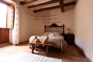 un dormitorio con una cama con una cita en la pared en Casa Rural Cal Baté en Pratdip