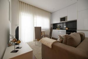 a living room with a couch and a kitchen at PIMENTA FOUR HOUSE in Amarante