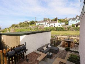 a patio with a couch and a piano and a table at 13 Quay Street in Amlwch