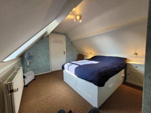 um quarto com uma cama grande num sótão em B&B Villa Giethoorn - canalview, privacy & parking em Giethoorn