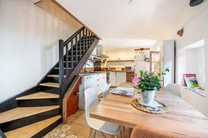 - une cuisine et une salle à manger avec une table en bois et des escaliers dans l'établissement Chez Malou & Hugo vue lac proche Suisse & stations !, à Saint-Gingolph