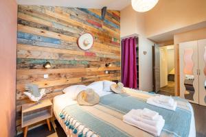 a bedroom with a wooden accent wall and a bed at Chez Malou & Hugo vue lac proche Suisse & stations ! in Saint-Gingolph