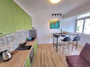a kitchen with green cabinets and a table and chairs at Orla Beach Apartment in Makarska