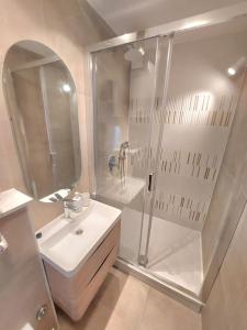 a white bathroom with a shower and a sink at Orla Beach Apartment in Makarska
