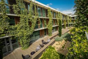 un immeuble d'appartements doté d'une cour avec des chaises et des plantes dans l'établissement Courtyard by Marriott Montpellier, à Montpellier