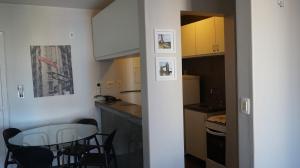Via Venneto Flat في فورتاليزا: مطبخ صغير مع طاولة وكراسي في الغرفة