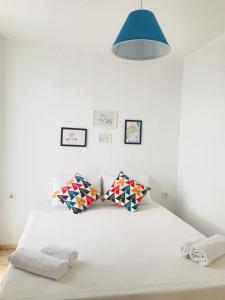 una camera da letto con letto bianco con cuscini e lampada blu di Aybüke Apart a Datça