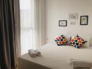 una camera da letto con un letto con due cuscini e una finestra di Aybüke Apart a Datça
