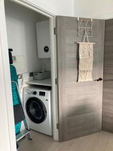 ニューキーにあるBeachside Apartmentの洗濯機付きのランドリールームへのドア