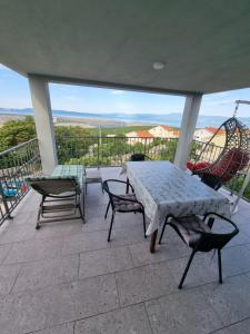 a table and chairs on a patio with a view at Apartments Katarina in Šmrika