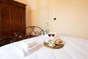 a table with a plate of food and two glasses of wine at Palazzo Zacà in Gallipoli