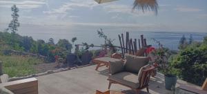 patio z krzesłem i widokiem na ocean w obiekcie Villa Magnolia w mieście Santa-Maria-di-Lota