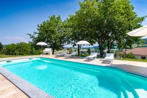 una piscina con due sedie e ombrelloni di TidHouse - Bed and Breakfast with private pool and free parking a Motta