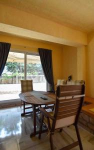 a dining room with a wooden table and chairs at Agia Marina apartment in Aghia Marina