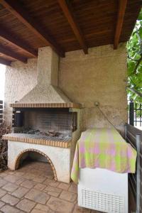 un patio con un horno al aire libre con una mesa en Agia Marina apartment, en Aghia Marina