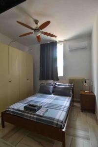 1 dormitorio con 1 cama y ventilador de techo en Agia Marina apartment, en Aghia Marina