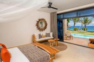 a living room with a bed and a view of the ocean at Aldiana Club Zanzibar Kwanza in Kizimkazi