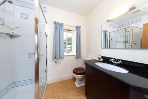 a bathroom with a sink and a toilet and a mirror at Charlton Gate in Greenhaugh +20 photos