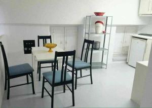 Cosy Appartment في لشبونة: مطبخ مع طاولة وكراسي في مطبخ