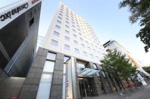 a tall white building on a city street at Richmond Hotel Fukuoka Tenjin in Fukuoka