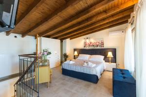 a bedroom with a bed and a blue chair at Penelope Home in Panormos Rethymno