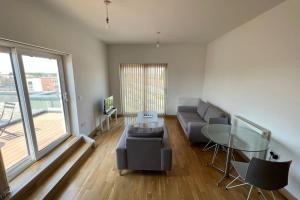 a living room with a couch and a glass table at Modern 2 bed flat with balcony in Southend-on-Sea +6 photos