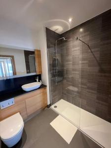 a bathroom with a shower and a toilet and a sink at Modern 2 bed flat with balcony in Southend-on-Sea