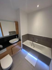 a bathroom with a toilet and a tub and a sink at Modern 2 bed flat with balcony in Southend-on-Sea