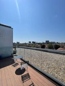 a balcony with two chairs and a table on a roof at Modern 2 bed flat with balcony in Southend-on-Sea