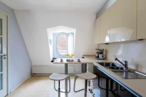 una pequeña cocina con fregadero y 2 taburetes en My Chiado Suite en Lisboa