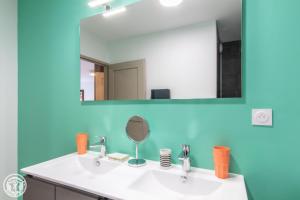 uma casa de banho com um lavatório branco e um espelho. em Gite Annecy 202 - Au Royaume des Castors - Appt 202 em Doussard
