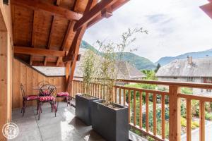 d'un balcon avec une table, des chaises et des montagnes. dans l'établissement Gite Annecy 202 - Au Royaume des Castors - Appt 202, à Doussard