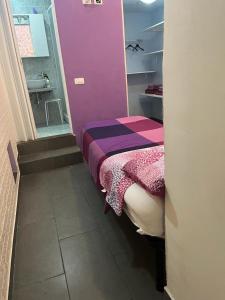 a small room with a bed and a bathroom at Violet 27 in Florence