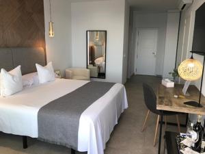 a hotel room with a large bed and a desk at Villa El Buzo in Zahara de los Atunes