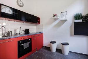 una cocina con armarios rojos y un reloj en la pared en Trendy apartment at the hippest location, en Budapest 11 fotos más
