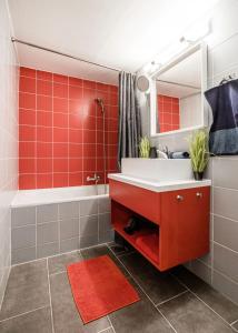 Un baño con azulejos rojos, lavabo y bañera. en Trendy apartment at the hippest location, en Budapest